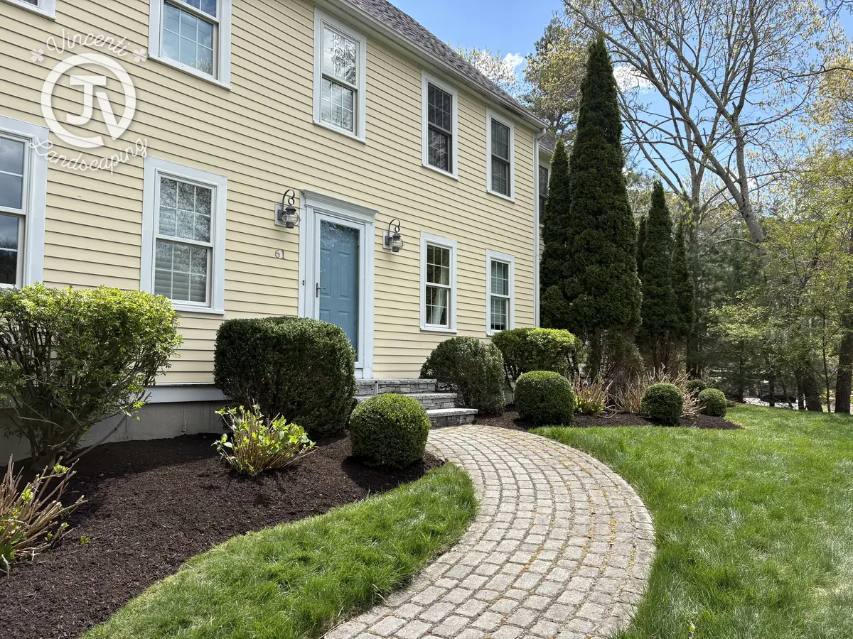 Cobblestone walkway and garden beds by Vincenti Landscaping
