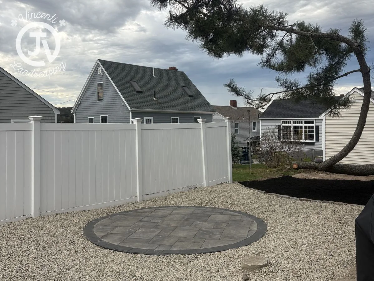 Round paver patio in a gravel yard installed by Vincenti Landscaping in Marshfield, MA